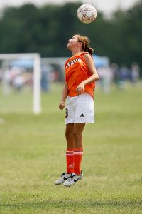 Girl heading soccer ball