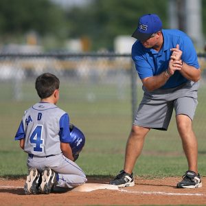 Boy getting batting tips from coach